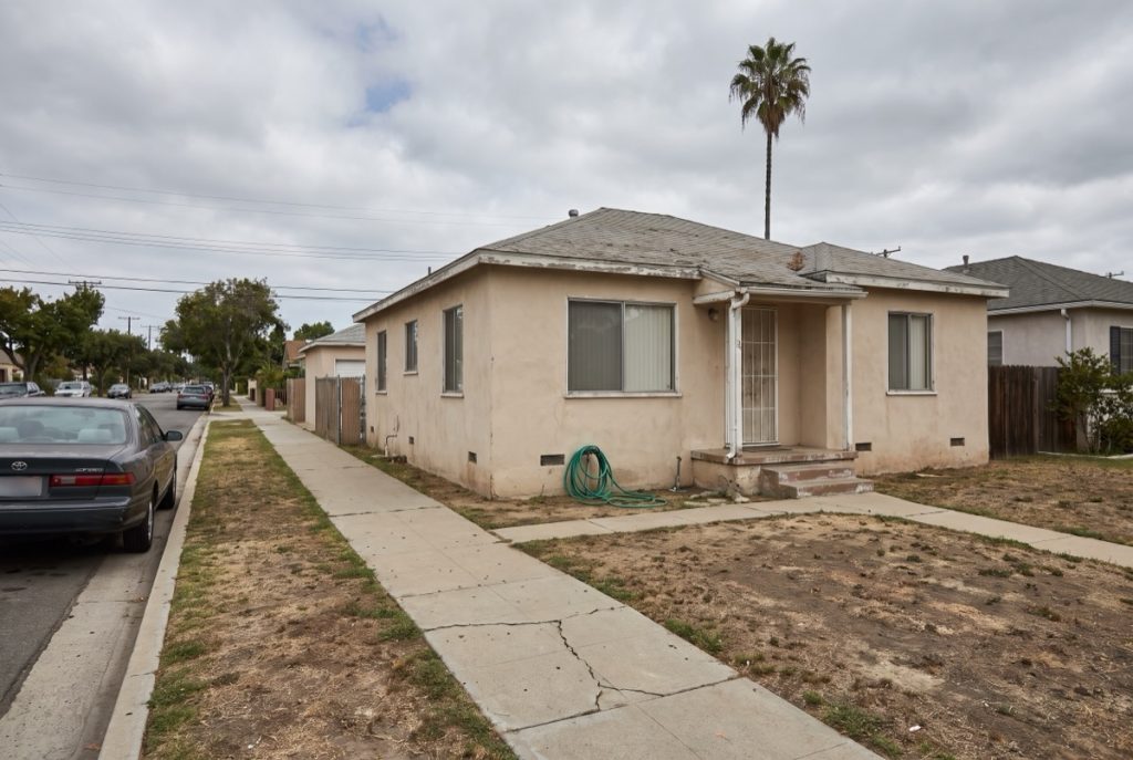 Single-story stucco house in Los Angeles with a dry front lawn and cracked walkway